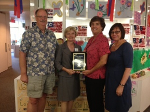Board Members: Les Jones (President), M. Vega, Denise Clynes (also GGCOC President), Julie Duarte holding up the "Non-Profit of the Year" Award.  (In the background is July 4th artwork made by senior participants) 